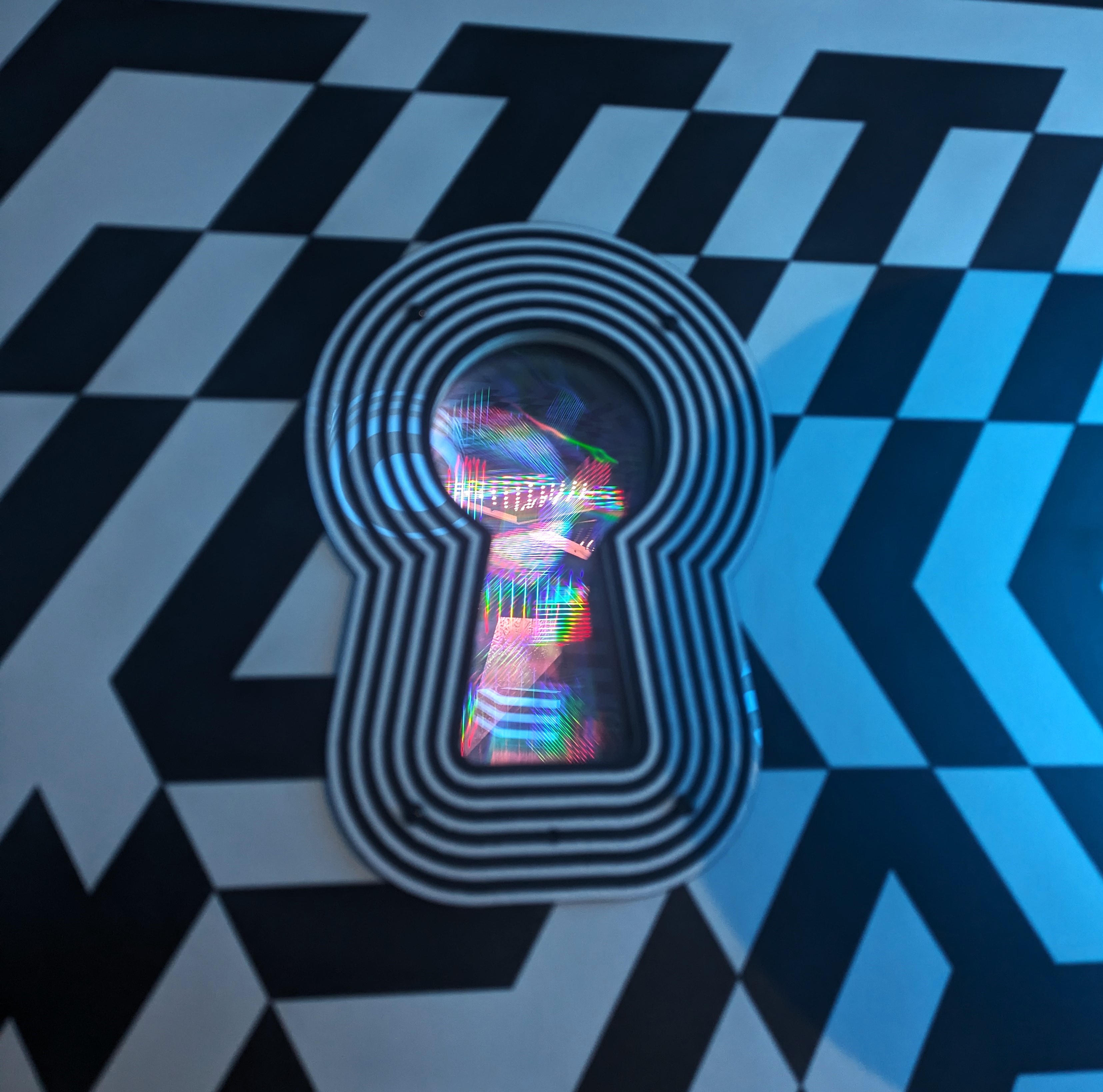 Light diffracted through a black and white keyhole window in Dazzle